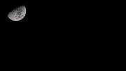 a full moon is seen in the dark sky